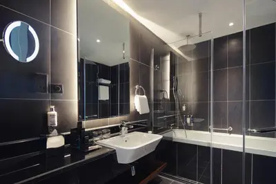 a bathroom with a sink and a mirror at Dukes The Palm Dubai Hotel in Dubai