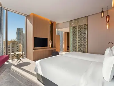 a bedroom with a large white bed and a tv at Rixos Premium Dubai JBR in Dubai