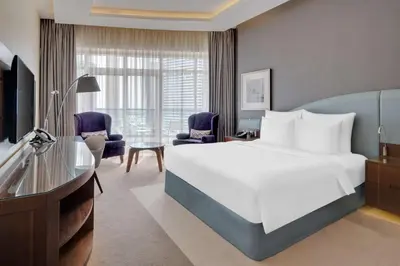 a bedroom with a large white bed and a desk at Radisson Blu Hotel, Dubai Waterfront in Dubai