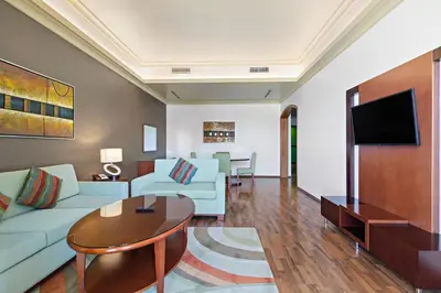a living room with a couch and a table at Al Khoory Hotel Apartments Al Barsha in Dubai
