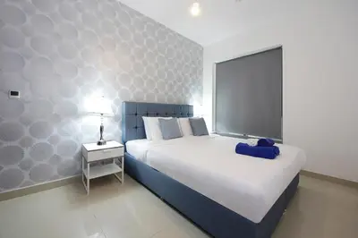 a bedroom with a bed with a blue blanket on it at New Arabian 29 Boulevard Downtown in Dubai