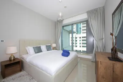 a bedroom with a white bed with a blue teddy bear on it at New Arabian 29 Boulevard Downtown in Dubai