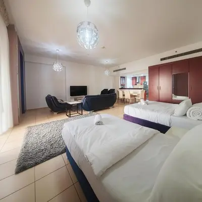 a hotel room with two beds and a living room at Elan Rimal2 Suites in Dubai