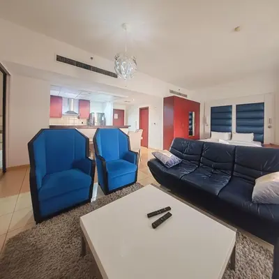 a living room with a couch and two blue chairs at Elan Rimal2 Suites in Dubai