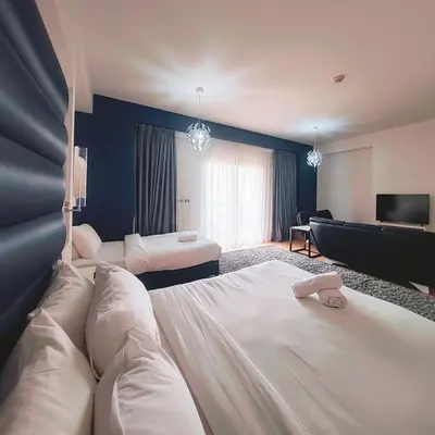a hotel room with two beds and a television at Elan Rimal2 Suites in Dubai