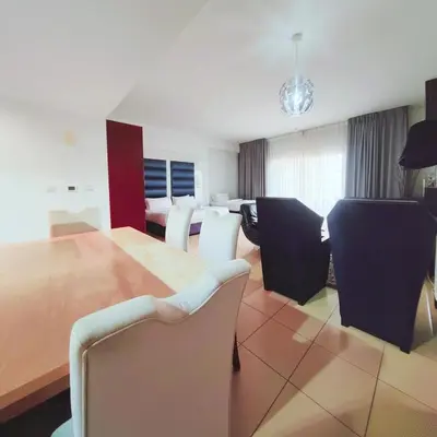 a living room with chairs and a dining room table at Elan Rimal2 Suites in Dubai
