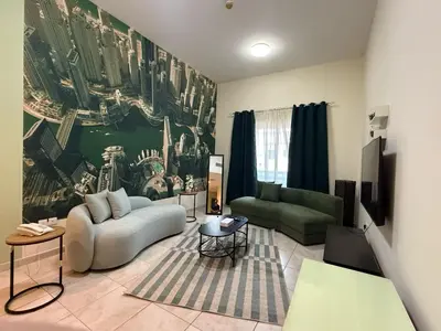 a living room with a couch and a tv at Al Raya Hotel Apartments in Dubai