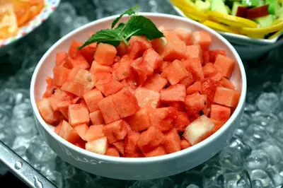 a bowl of diced fruit with a green leaf on top at Baity Hotel Apartments in Dubai