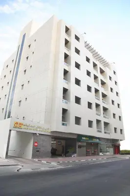 a large white building on the side of a street at Akas-Inn Hotel Apartment in Dubai