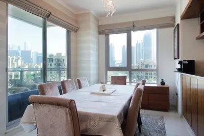 a dining room with a table and chairs and large windows at New Arabian Burj Residence 1 & 8 Downtown Dubai in Dubai