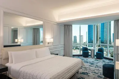 a hotel room with a bed and a large window at Le Meridien Mina Seyahi Beach Resort & Waterpark in Dubai