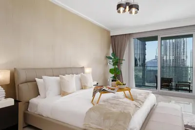 a bedroom with a large white bed and a large window at Maison Privee - Ultimate Living with Front-Row Views of Burj Khalifa & Dubai Fountains in Dubai