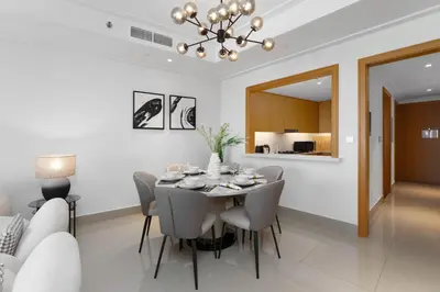 a dining room with a table and chairs at Maison Privee - Ultimate Living with Front-Row Views of Burj Khalifa & Dubai Fountains in Dubai