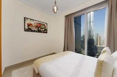 a bedroom with a bed and a large window at Maison Privee - Ultimate Living with Front-Row Views of Burj Khalifa & Dubai Fountains in Dubai