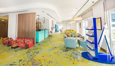 a room with couches and chairs on a yellow floor at MENA Plaza Hotel Albarsha At The Mall in Dubai