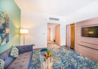 a living room with a couch and a tv at MENA Plaza Hotel Albarsha At The Mall in Dubai