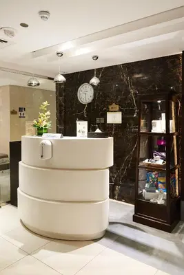 a counter in a room with a clock on a wall at Rose Park Hotel - Al Barsha, Opposite Metro Station in Dubai