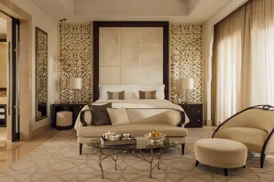 a bedroom with a bed and a couch and a table at One&Only The Palm Dubai in Dubai