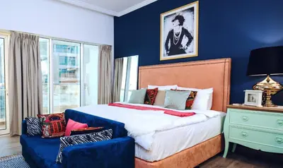 a bedroom with a large bed and a blue wall at Near Burj Khalifa, DownTown - Burj Al Nujoom in Dubai