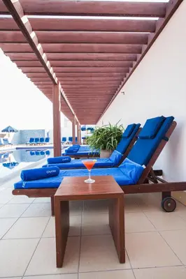 a patio with blue lounge chairs and a table at Citymax Hotel Bur Dubai in Dubai