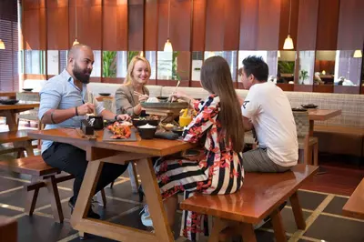 a group of people sitting at a table in a restaurant at Two Seasons Hotel & Apartments in Dubai