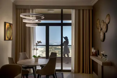 a dining room with a table and a large window at Two Seasons Hotel & Apartments in Dubai