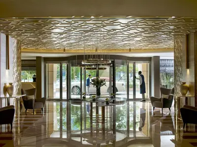 a lobby with a chandelier and a table and chairs at Two Seasons Hotel & Apartments in Dubai