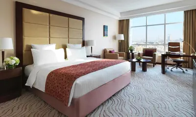 a hotel room with a large bed and a desk at Park Regis Kris Kin Hotel in Dubai