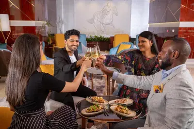 a group of people sitting around a table with glasses of wine at Park Regis Kris Kin Hotel in Dubai