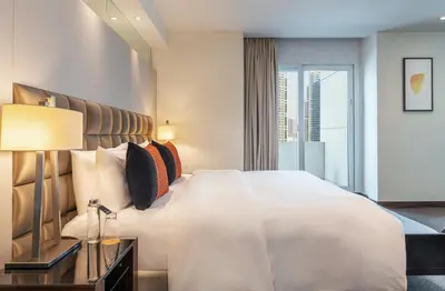 a bedroom with a large white bed and a window at voco - Bonnington Dubai by IHG in Dubai