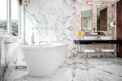 a white bathroom with a tub and a sink at voco - Bonnington Dubai by IHG in Dubai