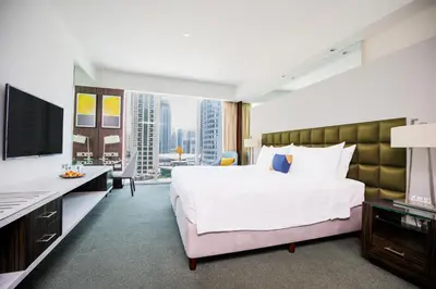 a hotel room with a bed and a desk with a computer at voco - Bonnington Dubai by IHG in Dubai