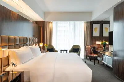 a hotel room with a large bed and a desk at voco - Bonnington Dubai by IHG in Dubai