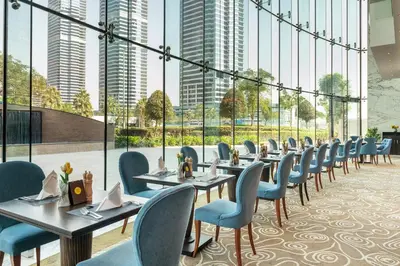 a row of tables and chairs in a restaurant with tall buildings at voco - Bonnington Dubai by IHG in Dubai