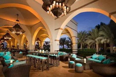 a resort lobby with chairs and tables and a chandelier at Jumeirah Zabeel Saray Dubai in Dubai