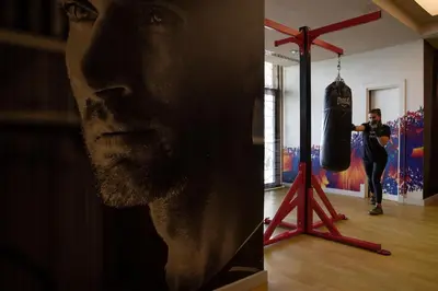 a man standing in a room with two boxing gloves at Jumeirah Zabeel Saray Dubai in Dubai