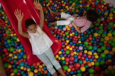 two children playing on a slide in a ball pit at Jumeirah Zabeel Saray Dubai in Dubai