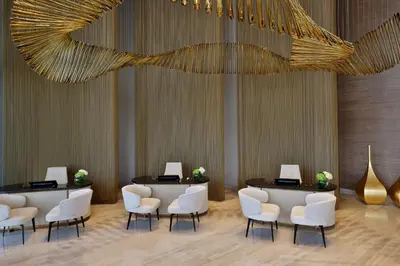 a waiting room with white chairs and a chandelier at The St. Regis Downtown Dubai in Dubai