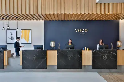 three people sitting at a table with laptops at voco Dubai by IHG in Dubai