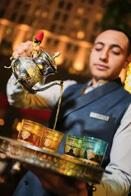 a man holding a serving tray with a toy chicken on it at Ritz Carlton DIFC Downtown Dubai in Dubai