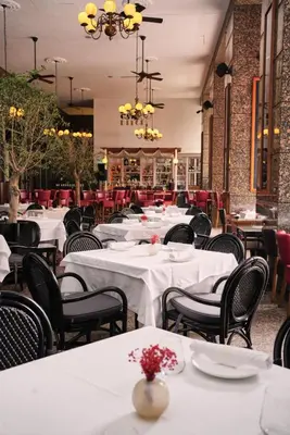 a dining room with white tables and black chairs at Ritz Carlton DIFC Downtown Dubai in Dubai