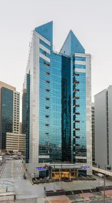 a group of tall glass buildings in a city at Golden Tulip Media Hotel in Dubai
