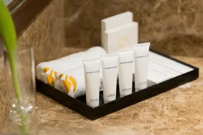 a group of four white candles on a tray at Golden Tulip Media Hotel in Dubai