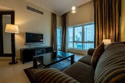 a living room with a couch and a tv at Gulf Oasis Hotel Apartments Fz LLC in Dubai