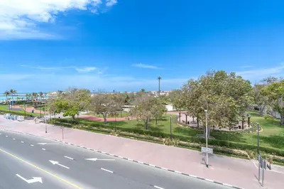an empty street with trees and a road at Beach Walk Boutique Jumeirah in Dubai