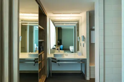 a bathroom with two sinks and two mirrors at Aloft Palm Jumeirah in Dubai