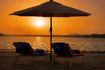 two chairs sitting under an umbrella on the beach at Aloft Palm Jumeirah in Dubai