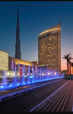 a large building with blue lights in front of it at Address Dubai Mall Fashion Avenue 1 bedroom 23 floor in Dubai