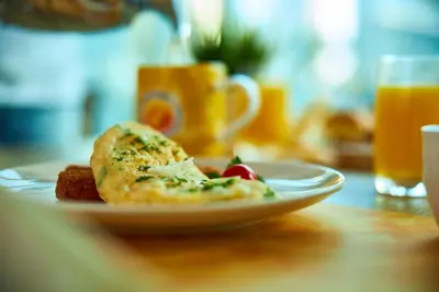 a plate of food on a table with orange juice at Dunes Hotel Apartment Oud Metha, Bur Dubai in Dubai
