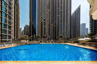 a large swimming pool in a city with tall buildings at Elite Royal Apartment - Full Burj Khalifa & Fountain view - Opal - 2 bedrooms plus 1 open bedroom without partition in Dubai